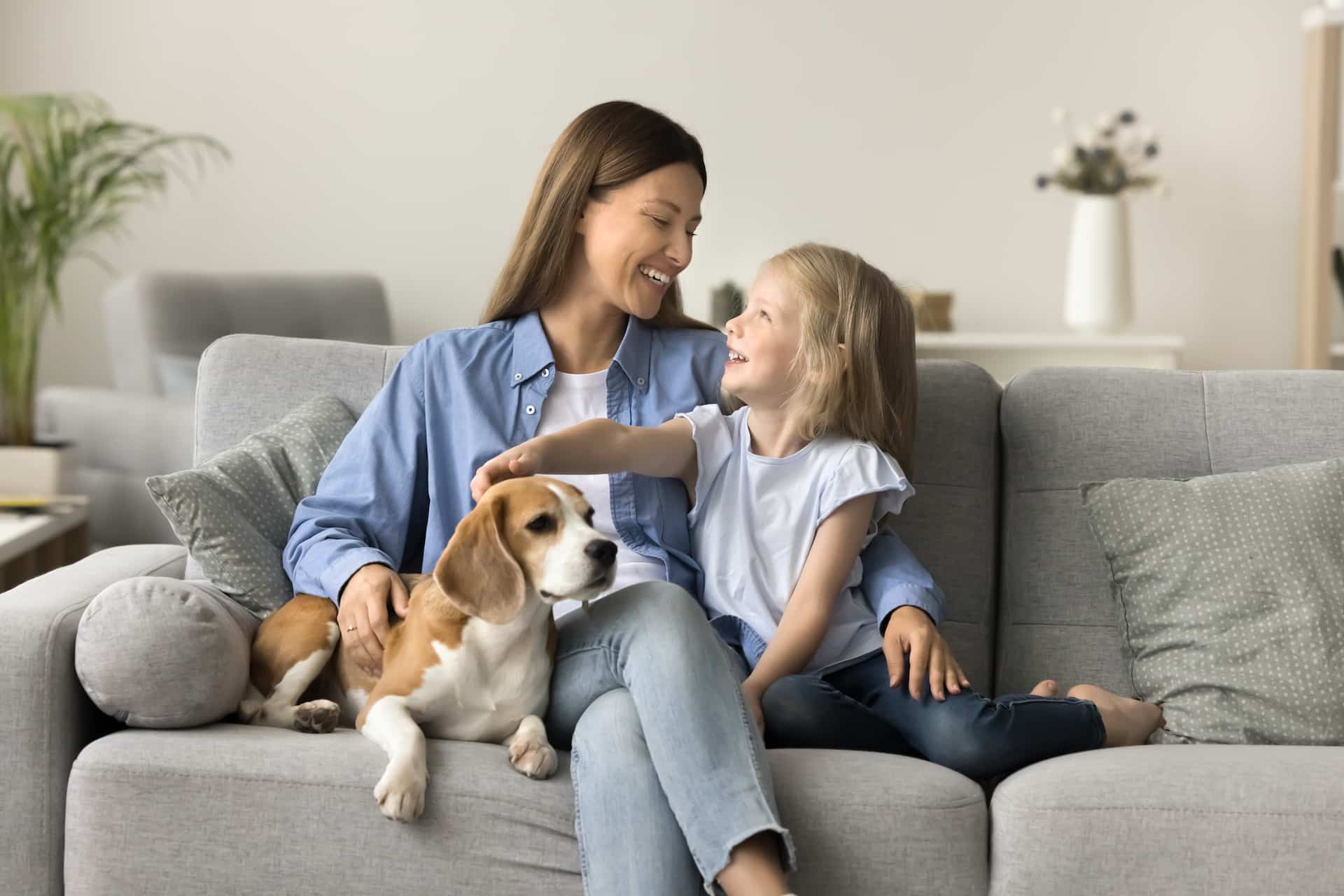 comfortable mom and child with their dog sitting on the couch
